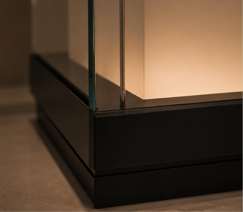 Black frame, glass enclosure and illuminated plinth material details