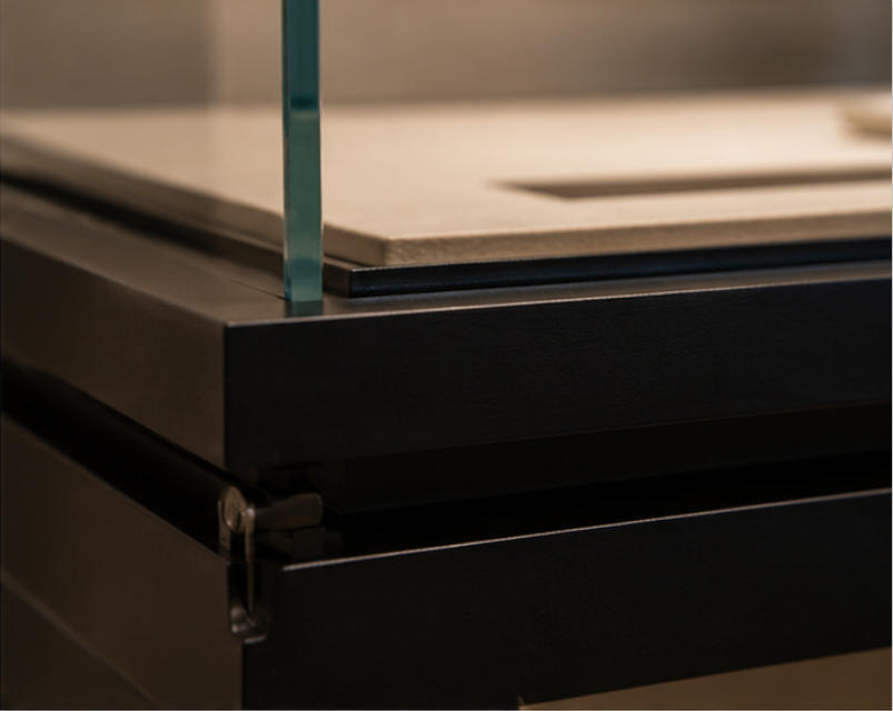 Two-legged black base, glass enclosure and angled platform material details