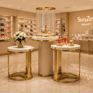 Marble Gold Display Table | Cylinder Glass Perfume Showcase - Sunzen 3 Front real shot marble gold three-piece perfume display set inside premium skincare boutique