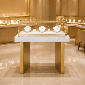 Marble Band Jewelry Table | Flat Gold Leg Rectangular Glass Showcase - Sunzen 3 Two-plinth marble front gold showcase placed inside light luxury jewelry retail boutique