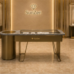Jewelry Marble Oval End Recessed Glass Display Counter | Bronze Cylinder V-Leg Asymmetrical Retail Showcase – Sunzen 6 Real Installation Shot In Avant-Garde Minimalist Designer Fine Jewelry Boutique Central Aisle Focal Zone