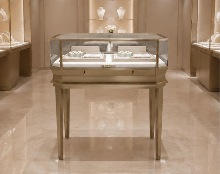 Slim gold octagon glass ring counter placed inside light luxury jewelry boutique